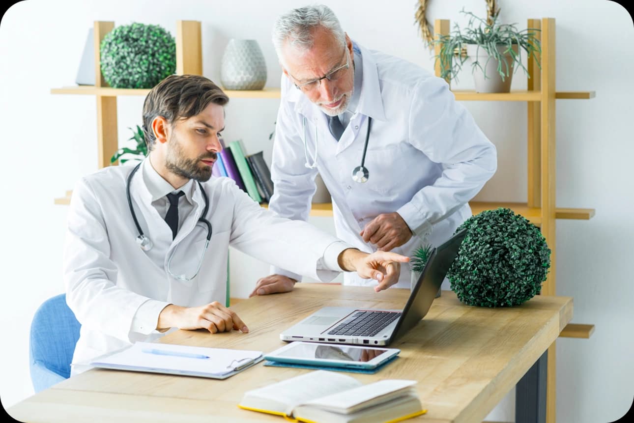 Two licensed healthcare providers discussing care for individuals in a clinical setting